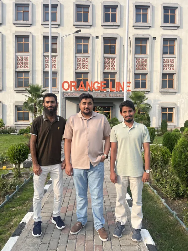 AI Data House team standing outside the Orange Line Metro building in Lahore