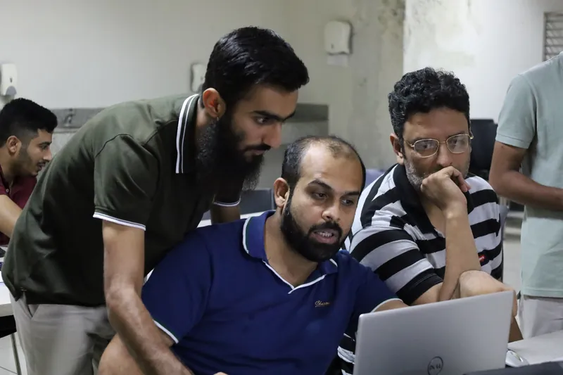 Trainer helping a staff member at a laptop